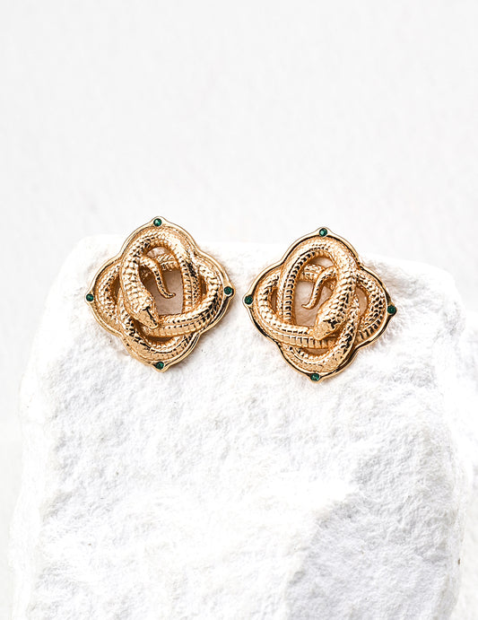 Gold serpent knot ear studs with green gemstone accents, vintage-inspired design.