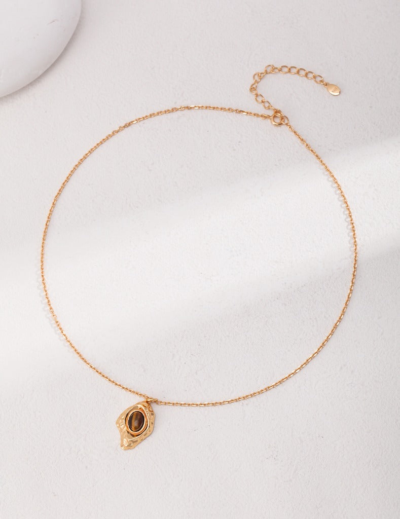 Gold-plated tiger eye necklace on black background - genuine stone with sterling silver chain